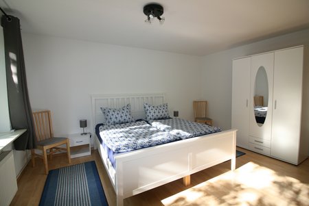 Ferienwohnung Wunderlich Schlafzimmer mit Doppelbett und Schrank.